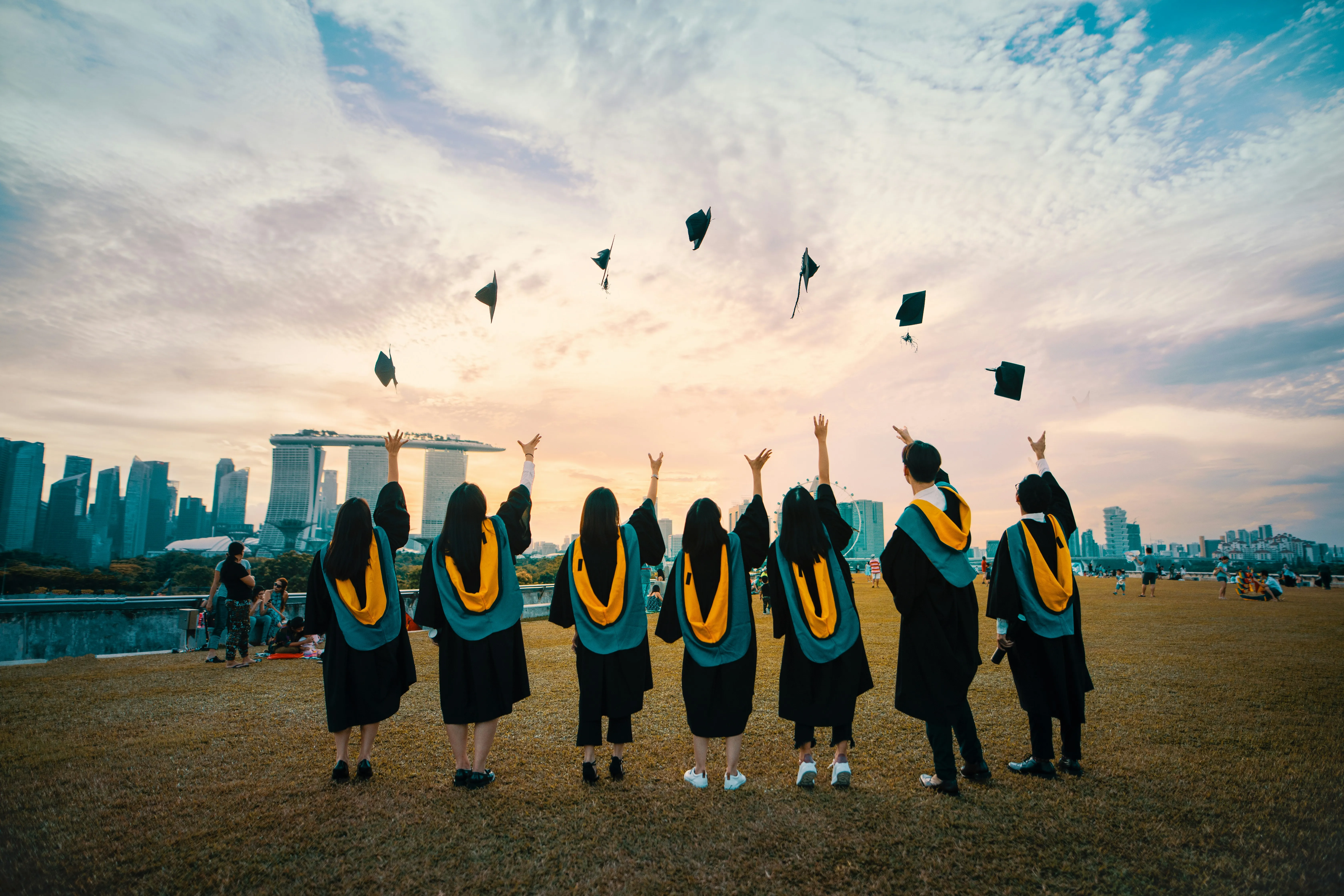 Graduates celebrating with city skyline backdrop