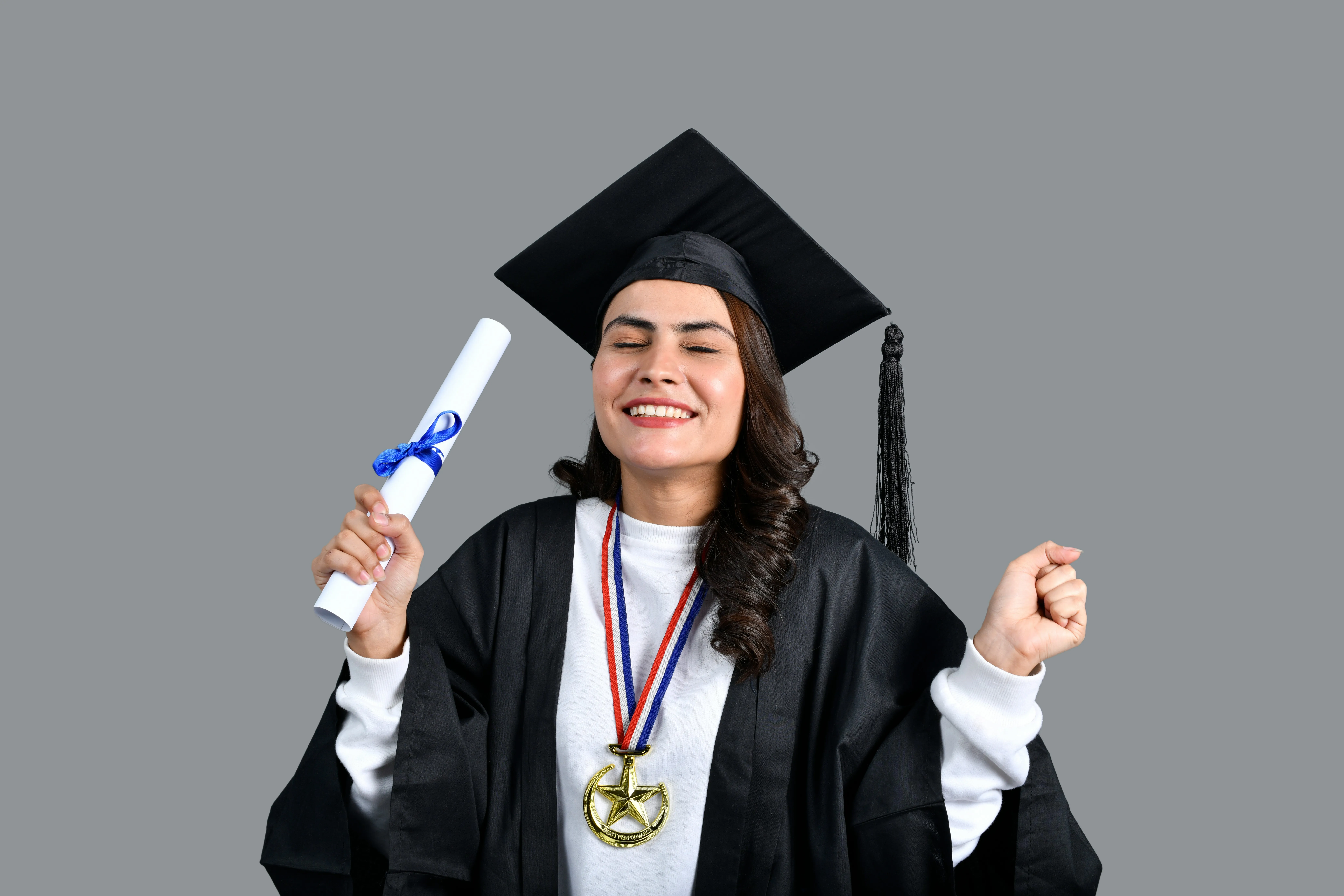Happy graduate holding diploma and scholarship medal